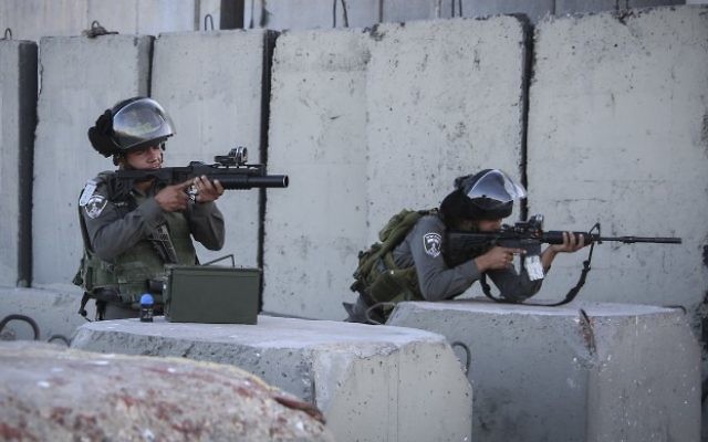 Des garde-frontières israéliens au point de contrôle de Qalandiya, près de Ramallah, en Cisjordanie, le 30 juin 2015. (Crédit : STR/Flash90) Des garde-frontières israéliens au point de contrôle de Qalandiya, près de Ramallah, en Cisjordanie, le 30 juin 2015. (Crédit : STR/Flash90)