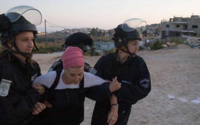 Les forces de sécurité israéliennes traînent une habitante juive venue manifester contre une évacuation dans l'implantation de Beit El, le 28 Juillet 2015 (Crédit photo: Nati Shohat / Flash90)