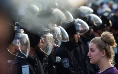 Les forces de sécurité israéliennes face à un manifestante juive lors d'une évacuation dans l'implantation de Beit El, le 28 Juillet 2015 (Crédit photo: Nati Shohat / Flash90)