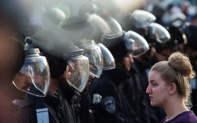 Les forces de sécurité israéliennes face à un manifestante juive lors d'une évacuation dans l'implantation de Beit El, le 28 Juillet 2015 (Crédit photo: Nati Shohat / Flash90)