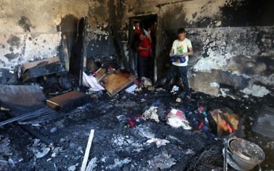 Des palestiniens examinent les dégâts d''une maison incendiée où un bébé a été tué, apparemment par des terroristes juifs, dans le village de Duma en Cisjordanie le 31 juillet, 2015  (Jaafar Ashtiyeh / AFP)