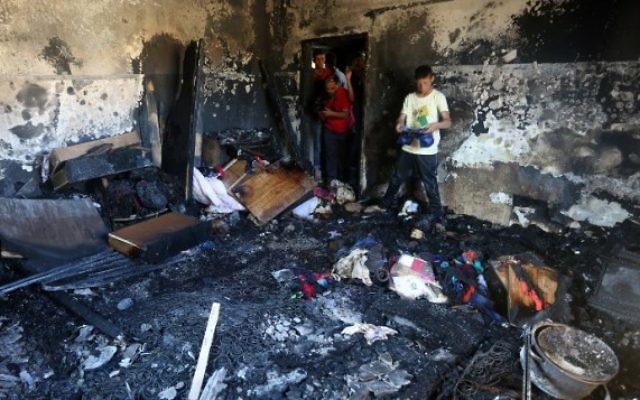 Des palestiniens examinent les dégâts d''une maison incendiée où un bébé a été tué, apparemment par des terroristes juifs, dans le village de Duma en Cisjordanie le 31 juillet, 2015  (Jaafar Ashtiyeh / AFP)