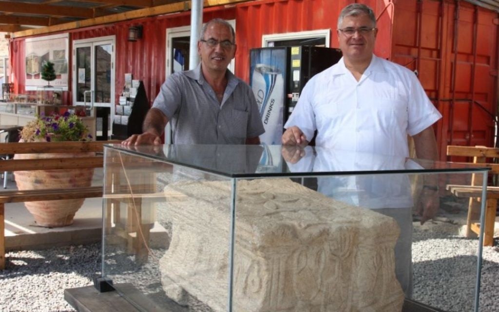 Père Juan (à droite) et l'archéologue Arfan Najjar avec la pierre de l'autel à Magdala (Crédit : Shmuel Bar-Am)