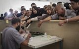 Des Palestiniens se rassemblent à la frontière de Rafah, dans le sud de la bande de Gaza, où ils attendent l'autorisation d'entrer en Egypte, le 12 juin 2015. (Crédit : AAED Tayeh/Flash90)