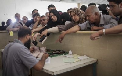 Des Palestiniens se rassemblent à la frontière de Rafah, dans le sud de la bande de Gaza, où ils attendent l'autorisation d'entrer en Egypte, le 12 juin 2015. (Crédit : AAED Tayeh/Flash90)