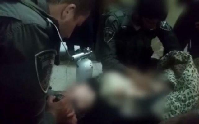 Le soldat israélien soignant la petite fille palestinienne à Hébron (Crédit : Tsahal/Facebook) Le soldat israélien soignant la petite fille palestinienne à Hébron (Crédit : Tsahal/Facebook)