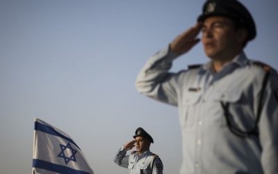 Des officiers de la police israélienne saluent les tombes des policiers décédés au cours d'une cérémonie commémorative dans la section de la police du cimetière militaire du mont Herzl à Jérusalem, le 19 avril 2015 (Crédit photo: Hadas Parush / Flash90)