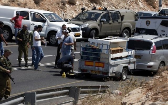 La police enquête après une attaque près de la colonie de Kohav Hashahar, le 31 juillet 2015. (Crédit : AFP PHOTO/THOMAS COEX) La police enquête après une attaque près de la colonie de Kohav Hashahar, le 31 juillet 2015. (Crédit : AFP PHOTO/THOMAS COEX)