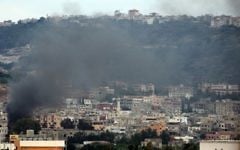 Des membres armés du Fatah à proximité d'un poste de contrôle de l'armée libanaise à l'entrée du camp de réfugiés palestiniens de Ain El-Helweh près de la ville portuaire du sud du Liban de Sidon - le 25 août 2015.  (Crédit : AFP PHOTO / MAHMOUD ZAYYAT)
