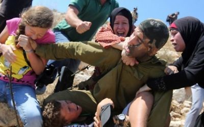 Ahed Tamini mord la main d'un soldat israélien à Nabi Saleh, près de Ramallah, en Cisjordanie. (Crédit photo: Abbas Momani / AFP)