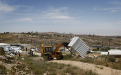 Photo des forces de sécurité israéliennes en train de démolir une structure construite illégalement dans un avant-poste en Cisjordanie (Crédit : Miriam Alster / flash 90)