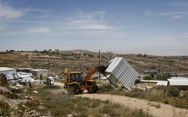Photo des forces de sécurité israéliennes en train de démolir une structure construite illégalement dans un avant-poste en Cisjordanie (Crédit : Miriam Alster / flash 90)