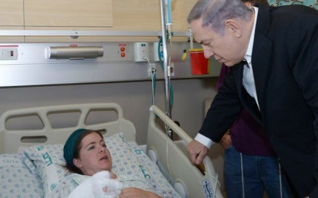 Le Premier ministre Benjamin Netanyahu rend visite à Inbar Azrak, 27 ans, qui a été blessée dans l'attaque à la bombe incendiaire de lundi soir, à l'hôpital Hadassah Ein Kerem à Jérusalem le 4 août 2015 (Amos Ben Gershom / GPO)