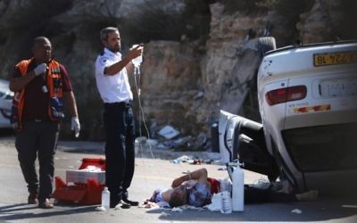 Des secouristes israéliens soignent l'un des trois soldats blessés dans un attentat à la voiture à un carrefour en Cisjordanie le 6 août, 2015 (Photo: AFP PHOTO / STR)