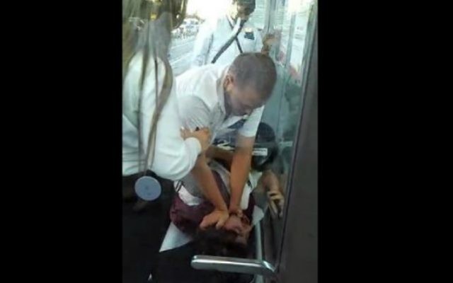 Un garde du tramway de Jérusalem agresse un touriste américain dans cette vidéo qui a été diffusée le 3 août  2015 sur la Dixième chaîne(Capture d'écran)
