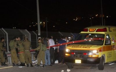 Les forces de sécurité israéliennes autour du corps d'un Palestinien qui a été abattu après avoir poignardé un Israélien le dimanche soir, 9 août 2015 à une station d'essence sur la route 443 qui mène à Jérusalem (Credit photo: Yonatan Sindel / Flash90)