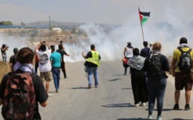 Des manifestants dans le village de Nabi Saleh en Cisjordanie face à des tirs de gaz lacrymogène après avoir jeté des pierres sur les soldats de Tsahal (Photo: Eric Cortellessa / Times of Israel)
