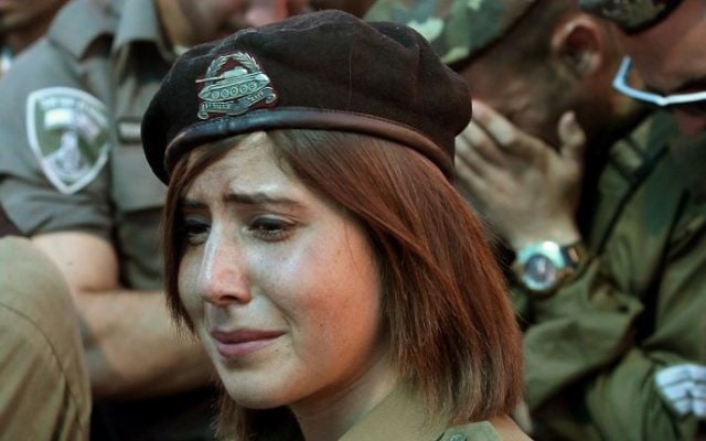 Des soldats et des amis israéliens pleurent lors des funérailles du caporal de soldat israélien Meidan Maymon Biton, 20 ans, au cimetière de la ville de Netivot le 29 juillet 2014. Meidan a été tué la veille quand un obus de mortier a été tiré à partir de la bande de Gaza et qui a frappé le conseil régional d'Eshkol (Crédit : Gil Cohen-Magen / AFP)