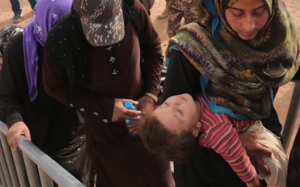 Des réfugiés syriens attendent au camp de fortune d'al-Roqban, sur la frontière avec la Syrie, avant d'être chassés par l'armée jordanienne de la ville orientale de Ruwaished où ils seront accueillis et contrôlés par les autorités jordaniennes le 10 septembre, 2015. Le dernier lot de réfugiés de la Syrie voisine sera envoyé à Ruwaished, à environ 380 km de la capitale Amman, à divers camps de réfugiés et des campements temporaires à travers le pays. (Crédit : AFP PHOTO / KHALIL MAZRAAWI)
