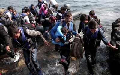 Des réfugiés syriens accostent sur l'île de Lesbos, après avoir traversé la mer Egée, le 3 septembre 2015 (Crédit : ANGELOS TZORTZINIS/ AFP)