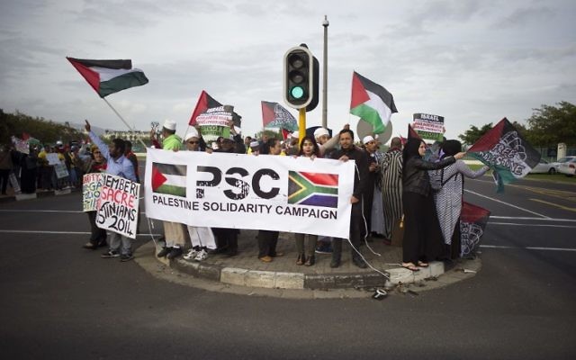 Des personnes brandissant des drapeaux palestiniens et une banderole « Palestine Solidarity Campaign » lors d'une manifestation contre le chanteur américain Pharrell Williams, près du Grand Casino où il tenait un concert au Cap, le 21 septembre 2015 (Crédit : AFP PHOTO / RODGER BOSCH) Des personnes brandissant des drapeaux palestiniens et une banderole « Palestine Solidarity Campaign » lors d'une manifestation contre le chanteur américain Pharrell Williams, près du Grand Casino où il tenait un concert au Cap, le 21 septembre 2015 (Crédit : AFP PHOTO / RODGER BOSCH)
