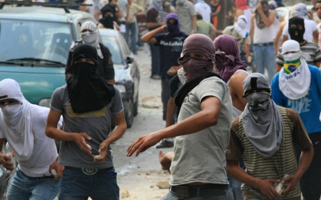 Des jeunes arabes jetant des pierres sur des forces de sécurité israéliennes lors d'affrontements à Jérusalem-Est  (Crédit photo: Kobi Gideon / Flash90)