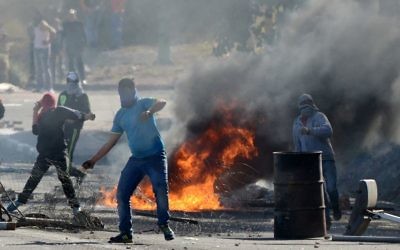 Les manifestants jetant des pierres sur les agents de la police des frontières israélienne à l'entrée de Kafr Kanna le 9 Novembre 2014 (Crédit: Flash90)