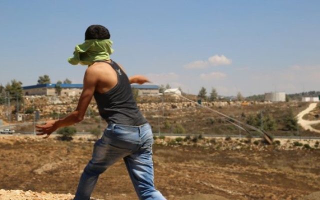 Un Palestinien du village de Nabi Saleh, en Cisjordanie, lance une pierre à l'aide d'une fronde sur des soldats israéliens, le 28 août 2015. Illustration. (Crédit : Eric Cortellessa/Times of Israël) Un Palestinien du village de Nabi Saleh, en Cisjordanie, lance une pierre à l'aide d'une fronde sur des soldats israéliens, le 28 août 2015. Illustration. (Crédit : Eric Cortellessa/Times of Israël)