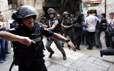 Policiers israéliens utilisant des grenades assourdissantes pour disperser des manifestants palestiniens dans la Vieille Ville de Jérusalem pendant des échauffourées sur le mont du Temple, le 15 Septembre 2015. (Crédit : Thomas Coex / AFP)