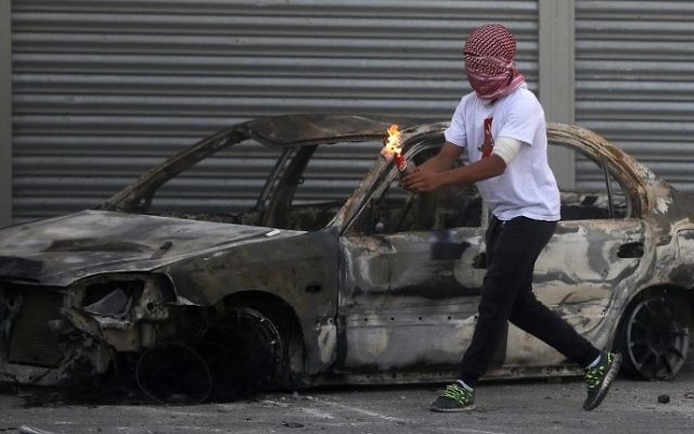 Un émeutier Palestinien masqué lançant un cocktail Molotov dans le camp de réfugiés de Shuafat, le 9 octobre 2015 (Crédit photo: Ahmad Gharabli/AFP) Un émeutier Palestinien masqué lançant un cocktail Molotov dans le camp de réfugiés de Shuafat, le 9 octobre 2015 (Crédit photo: Ahmad Gharabli/AFP)