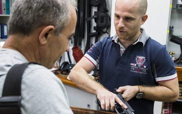 Un employé d'un armuriers et d'un stand dans la ville côtière israélienne de Tel Aviv montre une arme à un client le 13 Octobre 2015. La récente vague de troubles entre les Palestiniens et les Israéliens, qui a vu une série d'attaques au couteau et des manifestations violentes ont soulevé des craintes d'un troisième soulèvement palestinien, ou Intifada (Crédit : AFP PHOTO / JACK GUEZ) Un employé d'un armuriers et d'un stand dans la ville côtière israélienne de Tel Aviv montre une arme à un client le 13 Octobre 2015. La récente vague de troubles entre les Palestiniens et les Israéliens, qui a vu une série d'attaques au couteau et des manifestations violentes ont soulevé des craintes d'un troisième soulèvement palestinien, ou Intifada (Crédit : AFP PHOTO / JACK GUEZ)