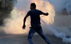 Un émeutier palestinien utilise une fronde lors d'affrontements avec les forces de sécurité israéliennes le 31 juillet à 2015 à proximité du camp de réfugiés palestinien de Jalazoun et l'implantation juive de Beit El, au nord de Ramallah, en Cisjordanie. (Crédit : AFP / ABBAS MOMANI)