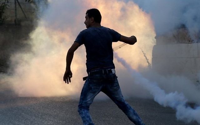 Un émeutier palestinien utilise une fronde lors d'affrontements avec les forces de sécurité israéliennes le 31 juillet à 2015 à proximité du camp de réfugiés palestinien de Jalazoun et l'implantation juive de Beit El, au nord de Ramallah, en Cisjordanie. (Crédit : AFP / ABBAS MOMANI) Un émeutier palestinien utilise une fronde lors d'affrontements avec les forces de sécurité israéliennes le 31 juillet à 2015 à proximité du camp de réfugiés palestinien de Jalazoun et l'implantation juive de Beit El, au nord de Ramallah, en Cisjordanie. (Crédit : AFP / ABBAS MOMANI)