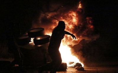 Un jeune Palestinien jette des pierres sur les soldats israéliens lors d'affrontements près de l'implantation juive de Bet El, dans la ville de Ramallah en Cisjordanie, le 4 octobre 2015 (Crédit photo: Abbas Momani / AFP)