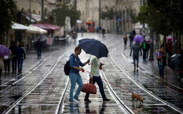 Des Israéliens avec leurs parapluies pour se protéger de la pluie tandis qu'ils marchent sur la rue de Jaffa, dans le centre de Jérusalem le 31 octobre 2014 (Crédit : Miriam Alster / Flash90) Des Israéliens avec leurs parapluies pour se protéger de la pluie tandis qu'ils marchent sur la rue de Jaffa, dans le centre de Jérusalem le 31 octobre 2014 (Crédit : Miriam Alster / Flash90)