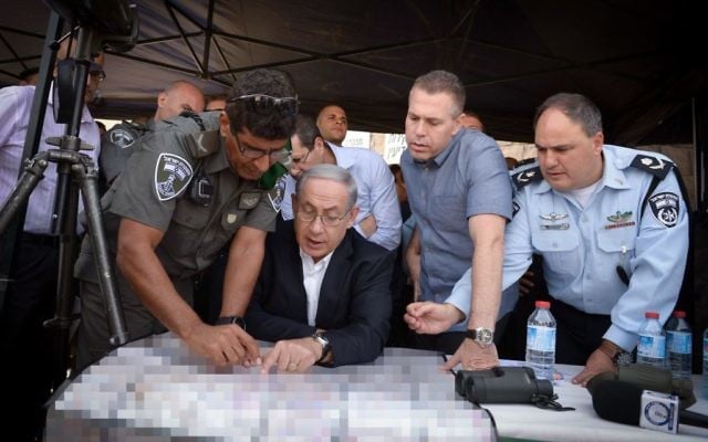 Benjamin Netanyahu, au centre, avec le ministre de la Sécurité publique Gilad Erdan, deuxième à droite, et les fonctionnaires de police lors d'une tournée à Jérusalem-Est le 16 septembre 2015 (Crédit : Amos Ben Gershom / GPO)