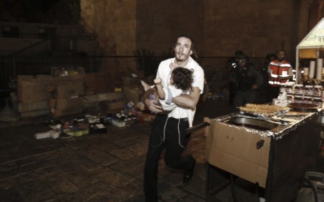 Un homme juif porte un bébé blessé dans une attaque au couteau dans la Vieille Ville de Jérusalem, le 3 octobre 2015. (Crédit : Yonatan Sindel/Flash90)