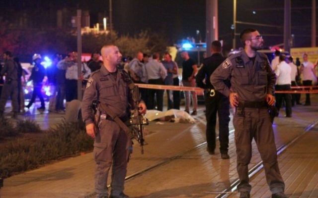 La police israélienne se tient près du corps d'un terroriste palestinien qui a poignardé un ado israélien de 15 ans à l'extérieur de Jérusalem, le 4 octobre, 2015. (Crédit : Flash90)