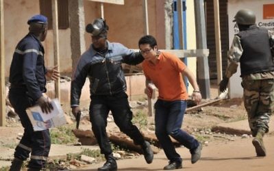 Illustration :Les forces de sécurité maliennes évacuent un homme d'une zone autour de l'hôtel Radisson Blu à Bamako le 20 novembre 2015. (Crédit : AFP PHOTO / HABIBOU KOUYATE)