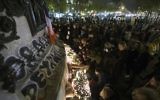Des gens allument des bougies dans un mémorial de fortune en hommage aux victimes des attaques de Paris le 14 novembre 2015 au lieu sur la place de la République à Paris. les djihadistes de l'Etat Islamique ont revendiqué une série d'attaques coordonnées par des hommes armés et des kamikazes à Paris qui ont tué au moins 129 (Crédit : AFP PHOTO / JOEL SAGET)