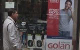 Un homme marchant à côté d'une affiche de publicité pour Golan Telecom à Jérusalem, le 5 novembre 2015. (Crédit : Lior Mizrahi / Flash90)