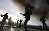Palestiniens jettant des pierres sur les forces de sécurité israéliennes lors d'affrontements dans la ville palestinienne d'Al-Bireh à la périphérie de Ramallah, le 20 novembre 2015 (Crédit photo: Abbas Momani / AFP)