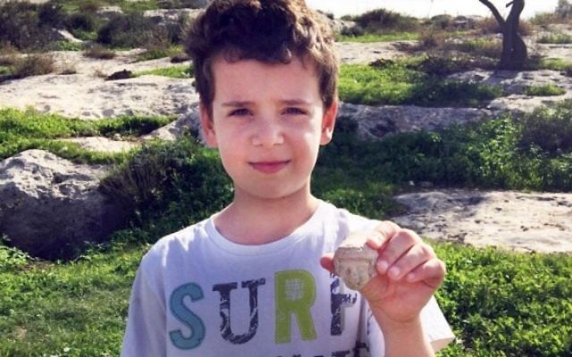Itai Halperin, 8 ans, et la tête d'une statuette de l'âge de fer qu'il a trouvée en marchant près de Tel Beit Shemesh (Photo: Arik Halperin, Autorisation d'Israel Antiquities Authority)