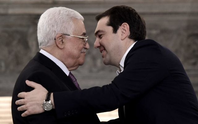Le Premier ministre grec Alexis Tsipras (d) s'approche du président de l'Autorité palestinienne Mahmoud Abbas lors d'une conférence de presse après une réunion le 21 décembre 2015 à Athènes. (Crédit : ARIS MESSINIS / AFP) Le Premier ministre grec Alexis Tsipras (d) s'approche du président de l'Autorité palestinienne Mahmoud Abbas lors d'une conférence de presse après une réunion le 21 décembre 2015 à Athènes. (Crédit : ARIS MESSINIS / AFP)