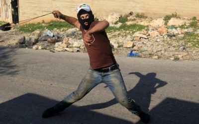 Un émeutier palestinien utilise une fronde pour lancer des pierres vers les forces de sécurité israéliennes lors d'affrontements près de Naplouse, le 11 décembre 2015. Illustration. (Crédit : AFP/Jaafar Ashtiyeh)