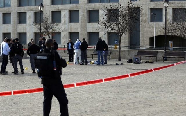 Des policiers se tiennent à côté du corps d'un assaillant palestinien qui a été abattu après une attaque le 26 décembre 2015, près de la Vieille Ville de Jérusalem (Crédit : Ahmad Gharabli / AFP)