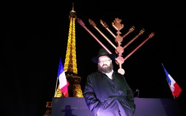 Le rabbin Mendel Azimov, président du Chabad de Paris, allume la ménorah de Hanoukka de vant la Tour Eiffelle 6 décembre 2015. (Crédit : Greg Scruggs/The Times of Israel)