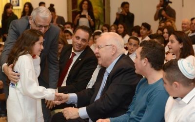 Le président Reuven Rivlin, au centre, accueille une jeune fille célébrant sa bat mitzvah à la résidence du président, à Jérusalem, le 21 décembre 2015 (Crédit : Mark Neiman / GPO)