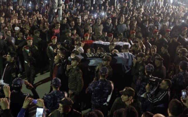 Les forces de sécurité de l'AP portent à Hébron les corps de deux des cinq terroristes Palestiniens restitués par Israël le 30 octobre 2015. Ils ont été tués dans des attaques au couteau contre des Israéliens (Crédit : Hazem Bader/ AFP)