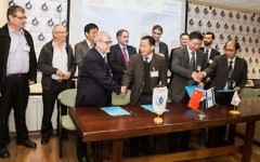 Entourés d'officiels israéliens et chinois, Zvi Shiller et Zhang Jin (centre gauche) signent un accord pour ouvrir un nouveau centre de recherche et développement robotiques en Israël. (Crédit : Autorisation)